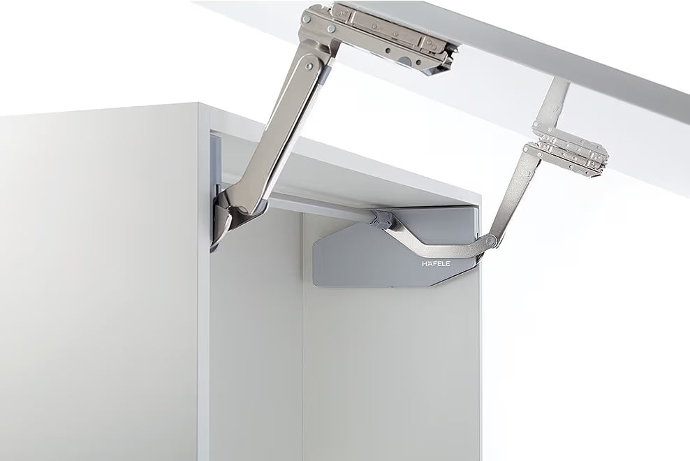 Metal cabinet hinge on a white cabinet door with a white background