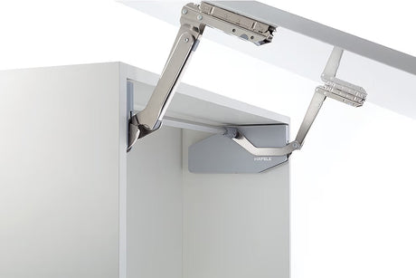 Metal cabinet hinge on a white cabinet door with a white background