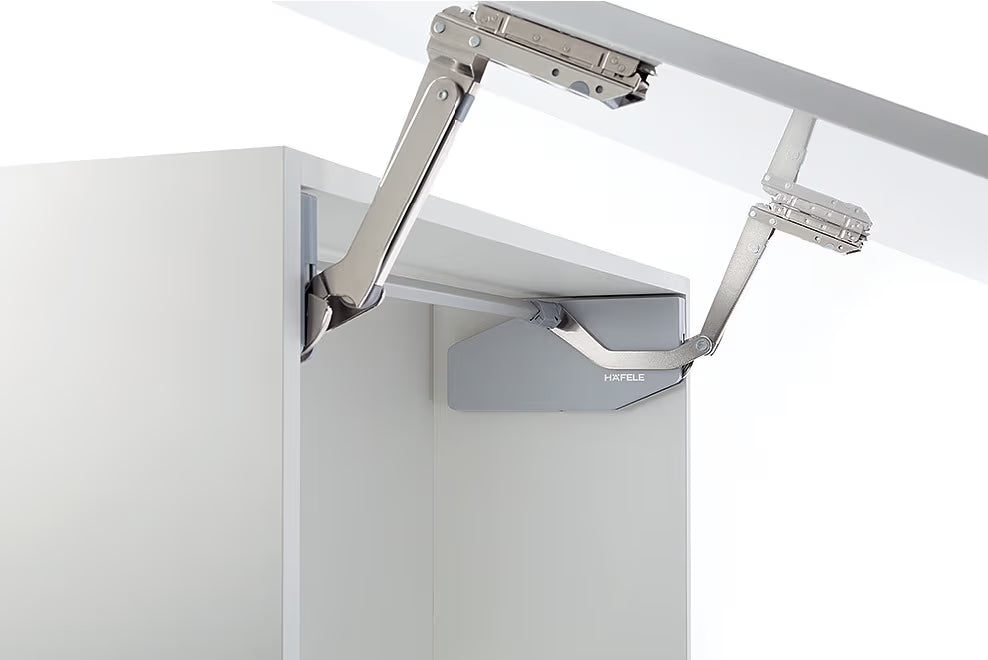 Metal cabinet hinge on a white cabinet door with a white background