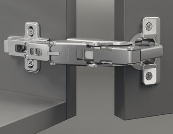 Close-up of a cabinet hinge on a gray background