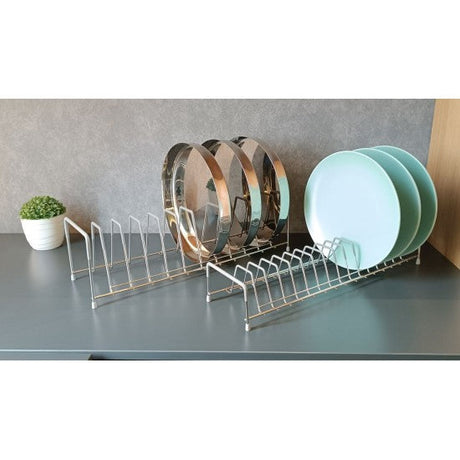 Dish rack with plates on a kitchen counter next to a potted plant.