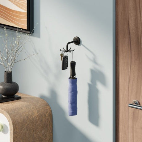 Wall-mounted coat rack with a blue umbrella holder and keys on a light gray wall.