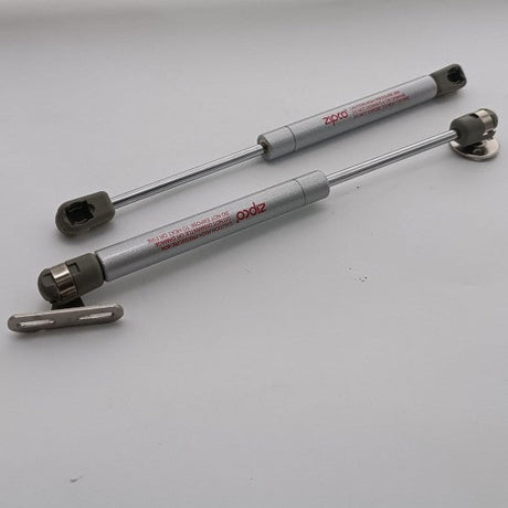 Two metal shock absorbers on a white background