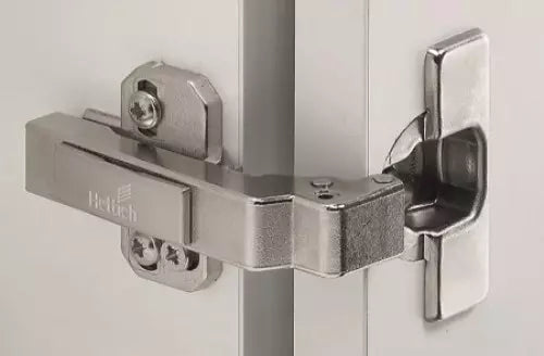 Close-up of a Hettich door hinge on a white background